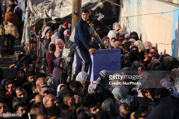Palestinians Wait To Receive Food Supplies At An Aid Distribution Centre Run By United Nations Relief And Works Agency , In Deir El-Balah, In The...