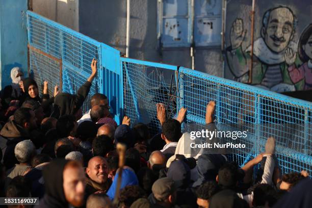 Palestinians Wait To Receive Food Supplies At An Aid Distribution Centre Run By United Nations Relief And Works Agency , In Deir El-Balah, In The...