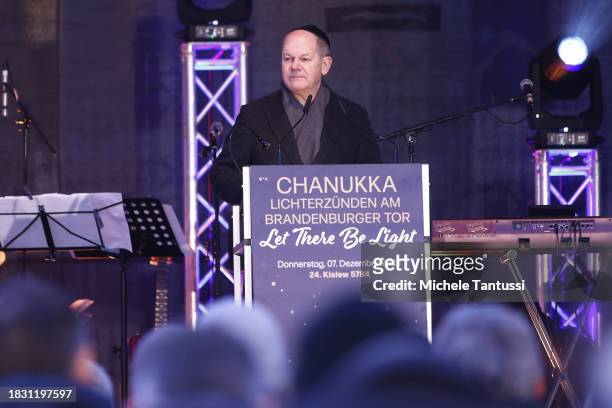 German Chancellor Olaf Scholz speaks during the ceremony to inaugurate a giant, illuminated menorah to celebrate the beginning of Hanukkah on...