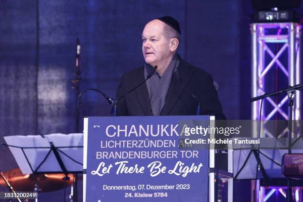 German Chancellor Olaf Scholz speaks during the ceremony to inaugurate a giant, illuminated menorah to celebrate the beginning of Hanukkah on...