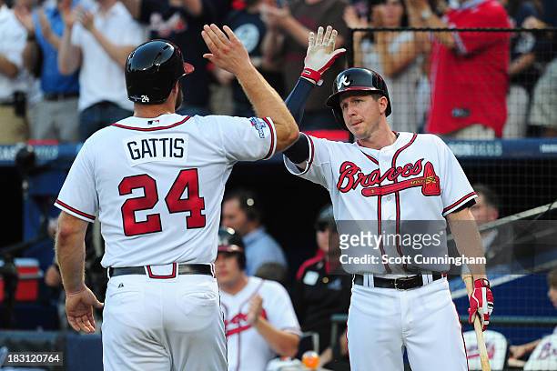 Evan Gattis and Elliot Johnson of the Atlanta Braves celebrate after Gattis scores in the second inning against the Los Angeles Dodgers during Game...