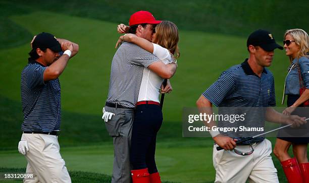 Keegan Bradley of the U.S. Team hugs his girlfriend Jillian Stacey on the 15th green after the team of Mickelson/Bradley defeated the Day/DeLaet team...