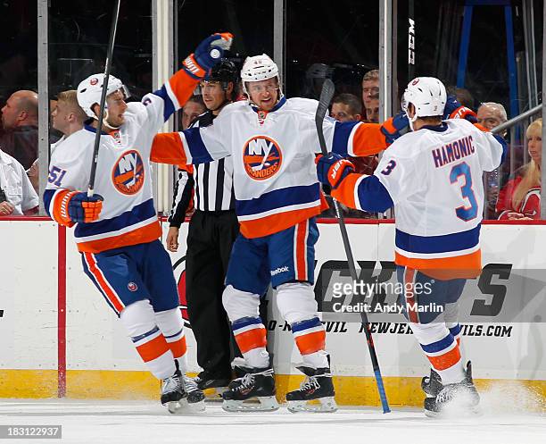 Michael Grabner of the New York Islanders is congratulated by his teammates after scoring a first-period goal against the New Jersey Devils during...