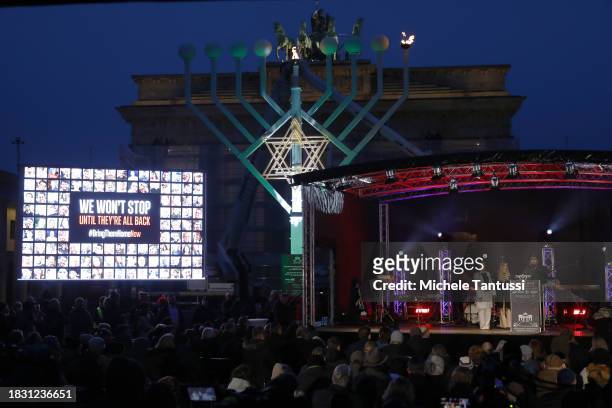 Na'ama and Ofir Weinberg and Rabbi Yehuda Teichtal speak as they inaugurate a giant, illuminated menorah to celebrate the beginning of Hanukkah on...