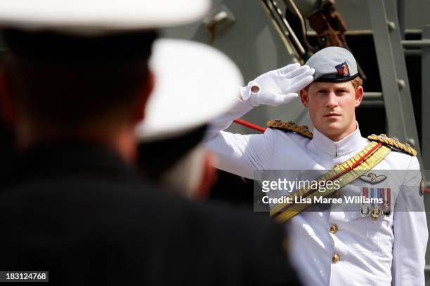Prince Harry salutes members of the Royal Australian Navy prior to boarding the Leeuwin on October 5, 2013 in Sydney, Australia. Over 50 ships...
