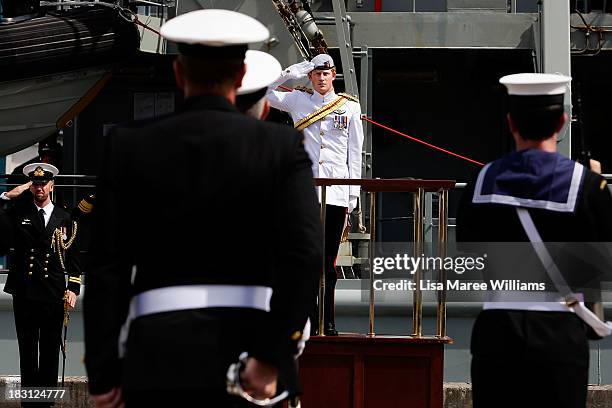 Prince Harry salutes members of the Royal Australian Navy prior to boarding the Leeuwin on October 5, 2013 in Sydney, Australia. Over 50 ships...