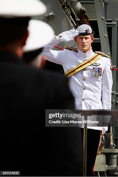 Prince Harry salutes members of the Royal Australian Navy prior to boarding the Leeuwin on October 5, 2013 in Sydney, Australia. Over 50 ships...