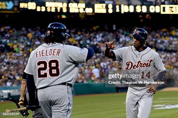 Austin Jackson of the Detroit Tigers high fives Prince Fielder after scoring on Miguel Cabrera signle against Bartolo Colon of the Oakland Athletics...