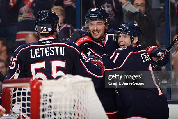 Artem Anisimov of the Columbus Blue Jackets celebrates his third period goal with Mark Letestu and Matt Calvert during the game against the Calgary...