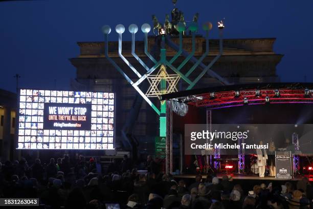 Na'ama Weinberg and Ofir Weinberg and Rabbi Yehuda Teichtal speak as they inaugurate a giant, illuminated menorah to celebrate the beginning of...