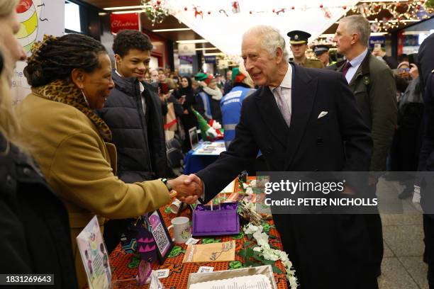 Britain's King Charles III visits the Christmas Market at Ealing Broadway Shopping Centre in west London on December 7 where he meets local business...