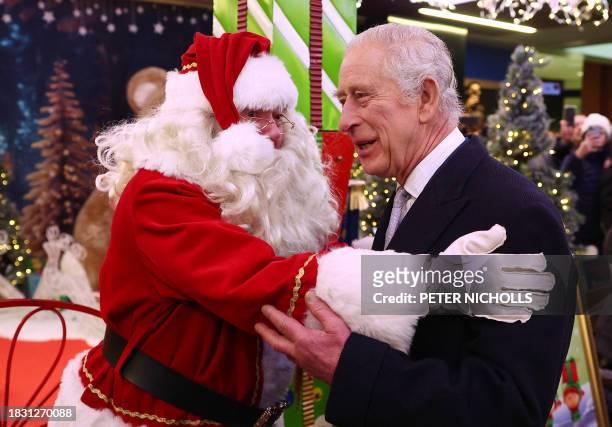 Britain's King Charles III reacts as he meets a Father Christmas during his visit to the Christmas Market at Ealing Broadway Shopping Centre in west...