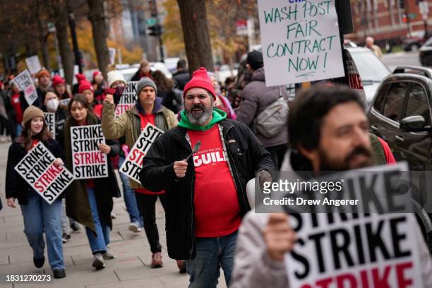 Employees of the Washington Post walk a picket line as they stage as 24 hour strike outside the Washington Post building December 7, 2023 in...