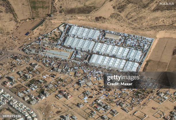 Maxar satellite imagery of crowds of people and shelters at UN aid center, Rafah . Please use: Satellite image 2023 Maxar Technologies.