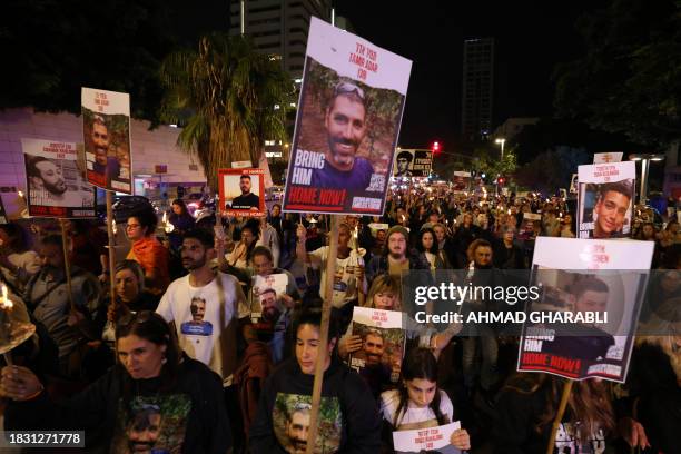 Families of hostages held in the Gaza Strip since October 7 and their supporters, carry pictures and candles as they walk toward a 138-branched...