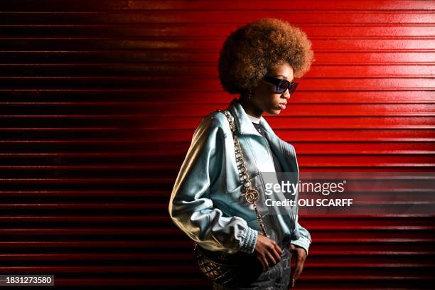 Guest poses for pictures prior to the start of the "Chanel Metiers d'art 2023-2024" fashion show, in Thomas Street, in Manchester, northern England,...