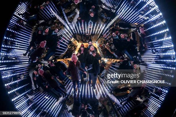People stand in a giant kaleidoscope, an installation by French artist Guillaume Marmin, during the Festival of Lights , in Lyon, central eastern...
