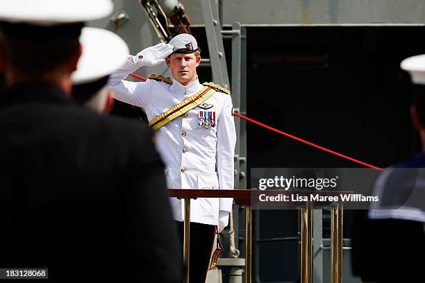 Prince Harry salutes members of the Royal Australian Navy prior to boarding the Leeuwin on October 5, 2013 in Sydney, Australia. Over 50 ships...