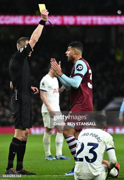 Referee Michael Salisbury shows a yellow card to West Ham United's Italian defender Emerson during the English Premier League football match between...