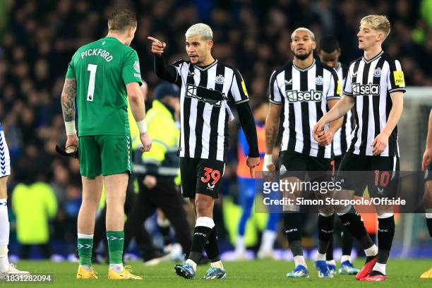 Bruno Guimaraes of Newcastle United points an accusing finger at Everton goalkeeper Jordan Pickford after the Premier League match between Everton FC...