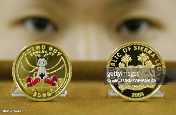Takako Kiyose, employee of Japan's Taisei Coins Corporation shows off one-once Sierra Leone gold coins of popular cartoon character Astro Boy in...