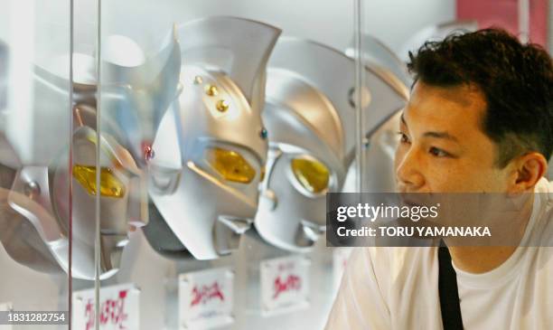 Man admires the heads of TV hero "Ultraman" brothers displayed at the Bandai Museum in Matsudo, suburban Tokyo, 20 July 2003. Japan's toy maker...