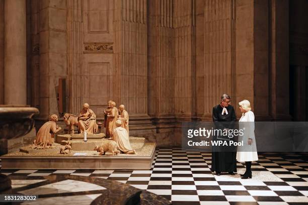 Queen Camilla with the Dean of St Paul's, The Very Revd Andrew Tremlett during the Maggie's cancer support centres annual carol concert at St Paul's...