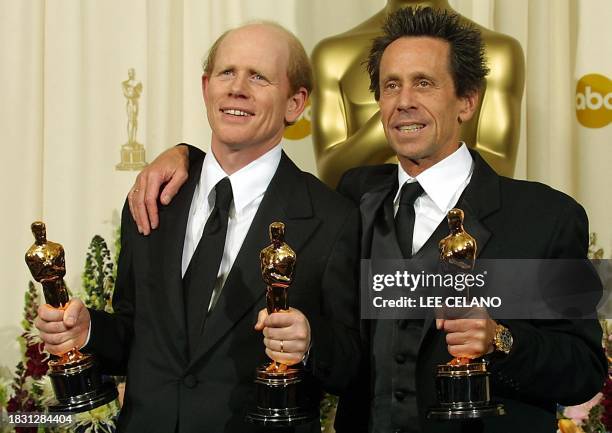 Director and producer Ron Howard and producer Brian Grazer hold their Oscar statues after winning the awards for best director and best picture for...