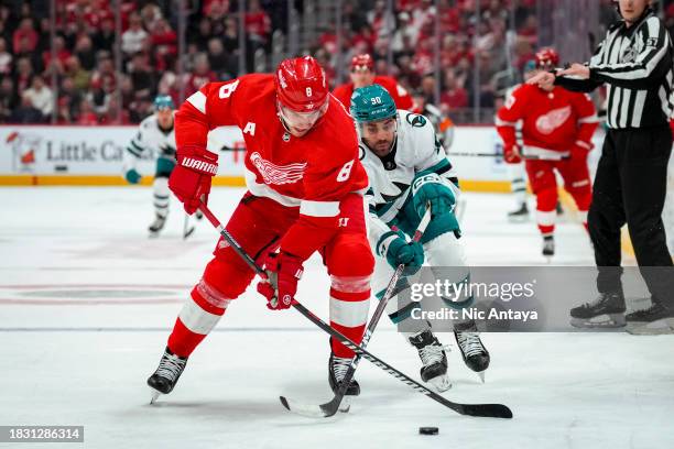 Ben Chiarot of the Detroit Red Wings and Justin Bailey of the San Jose Sharks go for the puck during the first period at Little Caesars Arena on...