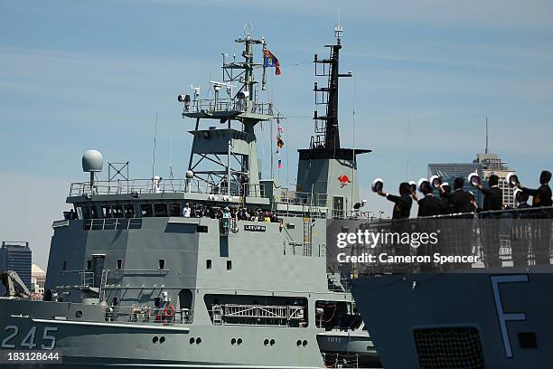 Prince Harry and Australian Governor-General Quentin Bryce onboard the HMAS Leeuwin are saluted by crew onboard the INS Sahyadri during the 2013...