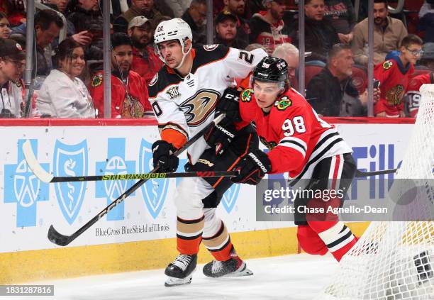Brett Leason of the Anaheim Ducks and Connor Bedard of the Chicago Blackhawks get physical in the first period at the United Center on December 07,...