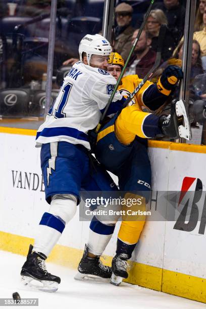 Erik Cernak of the Tampa Bay Lightning checks Spencer Stastney of the Nashville Predators during the third period at Bridgestone Arena on December 7,...