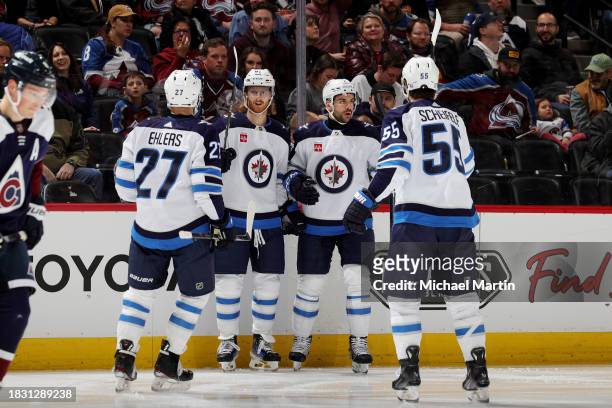 Nikolaj Ehlers, Kyle Connor, Dylan DeMelo and Mark Scheifele of the Winnipeg Jets celebrate a goal against the Colorado Avalanche at Ball Arena on...