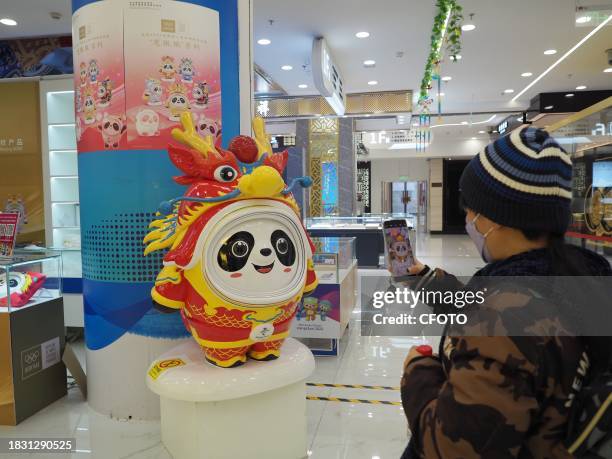 People shop for Long Dundun, a special edition of Bing Dwen Dwen, the mascot of the Beijing Winter Olympics, at WANGFUJING GONGMEI EMPORIUM in...