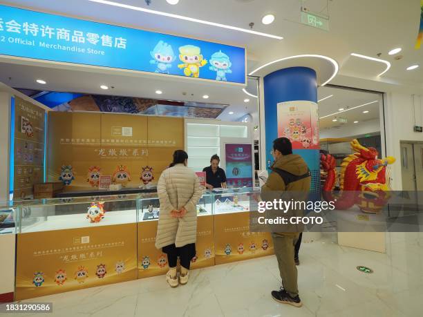 People shop for Long Dundun, a special edition of Bing Dwen Dwen, the mascot of the Beijing Winter Olympics, at WANGFUJING GONGMEI EMPORIUM in...