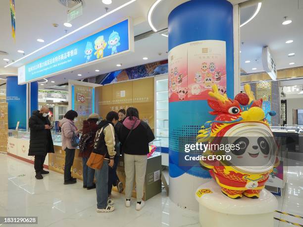 People shop for Long Dundun, a special edition of Bing Dwen Dwen, the mascot of the Beijing Winter Olympics, at WANGFUJING GONGMEI EMPORIUM in...