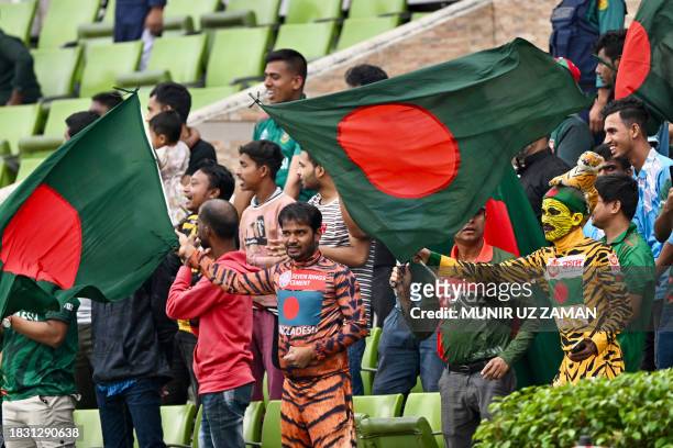 Fans wave the national flag of Bangladesh during the third day of the second Test cricket match between Bangladesh and New Zealand at the...