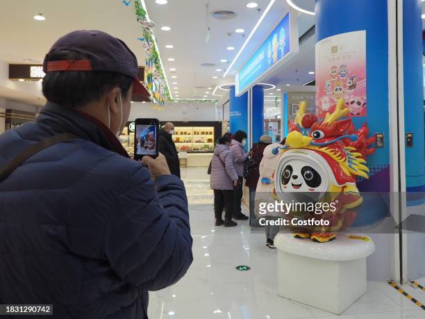 People shop for Long Dundun, a special edition of Bing Dwen Dwen, the mascot of the Beijing Winter Olympics, at WANGFUJING GONGMEI EMPORIUM in...