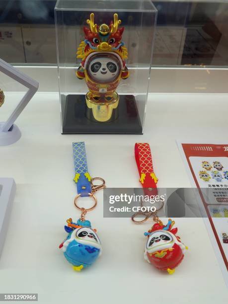 People shop for Long Dundun, a special edition of Bing Dwen Dwen, the mascot of the Beijing Winter Olympics, at WANGFUJING GONGMEI EMPORIUM in...