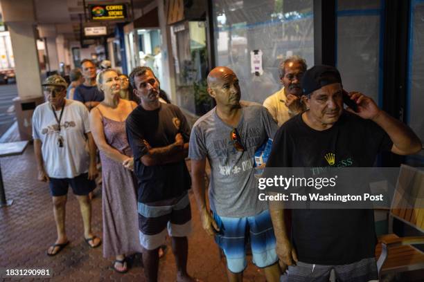 People stand in line to pick up free salads with seared mahi mahi for dinner at Joey's Kitchen in Napili on West Maui on Aug. 20, 2023. Joey's...