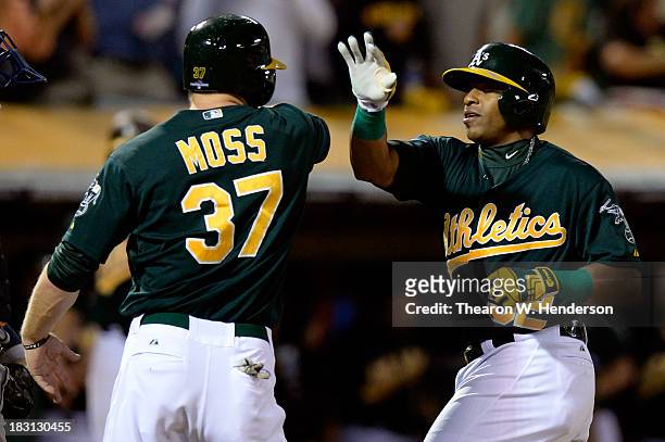 Yoenis Cespedes of the Oakland Athletics celebrates with teammate Brandon Moss after hitting a two run home run in the seventh inning against Max...