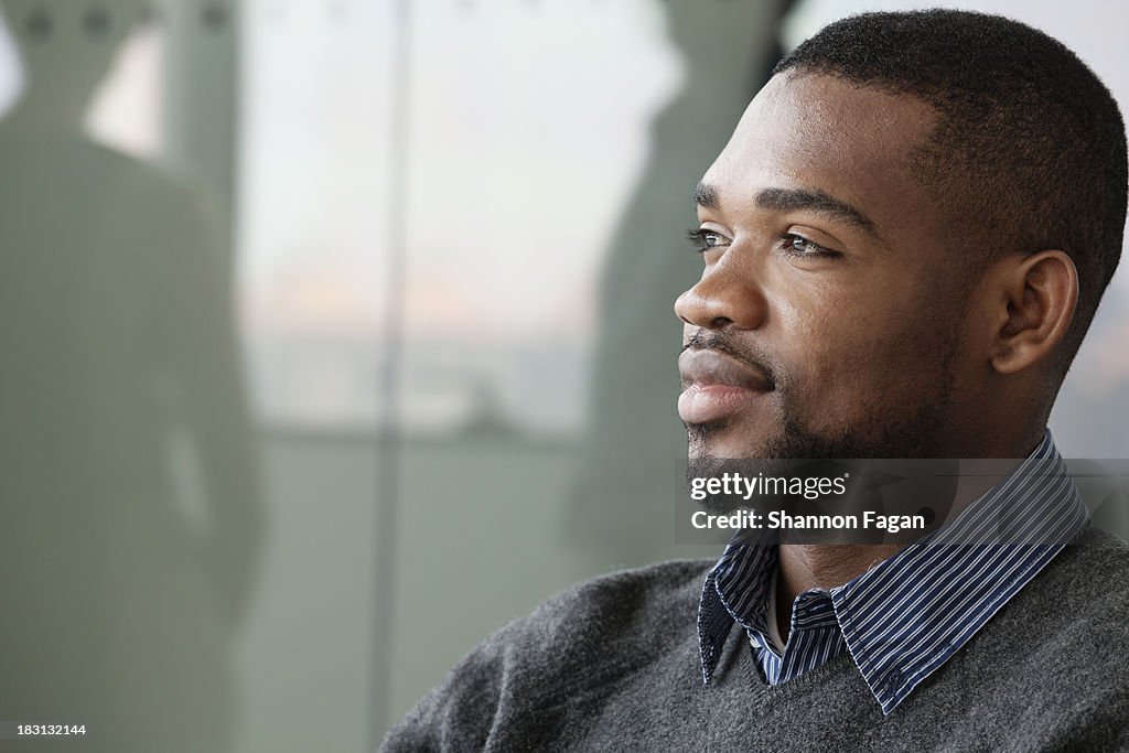 Portrait of young smiling businessman looking away