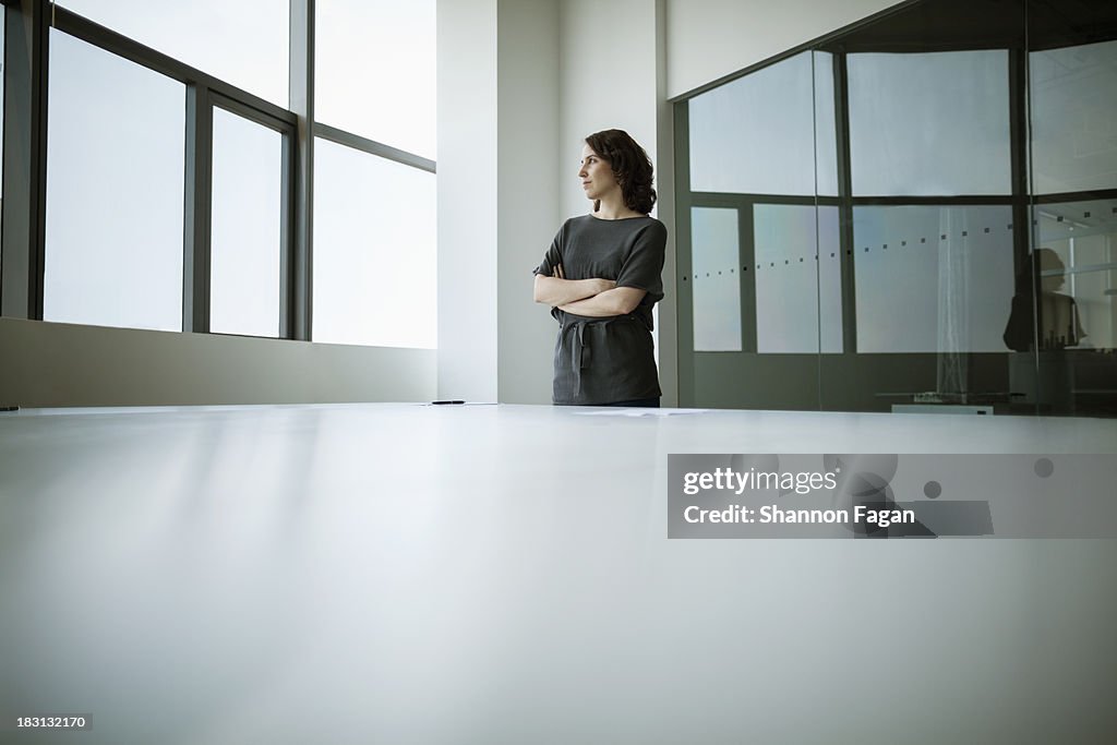 Businesswoman with arms crossed looking out