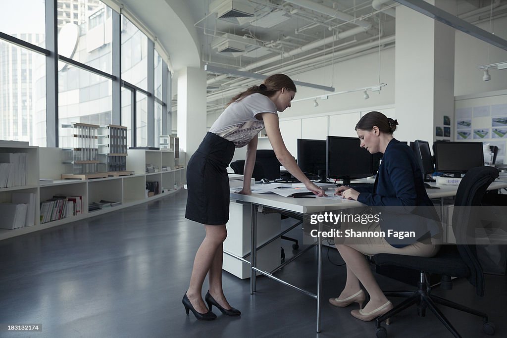 Two office coworkers discussing