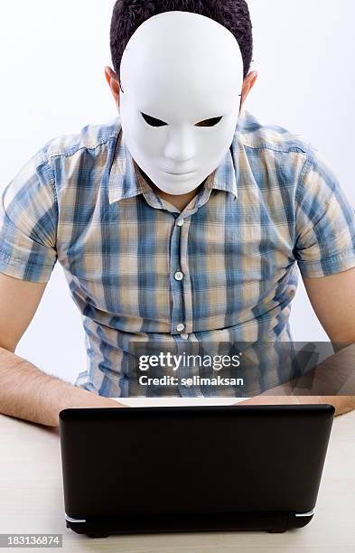vertical foto de hombre con máscara usando computadora para la piratería informática - anti mask fotografías e imágenes de stock