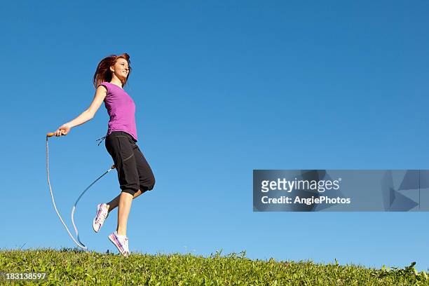 young woman jumping rope - woman skipping stock pictures, royalty-free photos & images