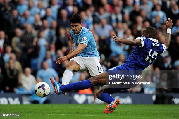 Sergio Aguero of Manchester City shoots past Sylvain Distin of Everton to score his team's second goal during the Barclays Premier League match...