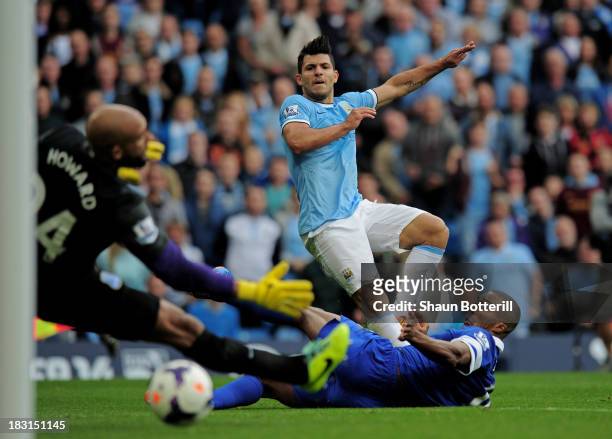 Sergio Aguero of Manchester City shoots past Sylvain Distin and Tim Howard of Everton to score his team's second goal during the Barclays Premier...