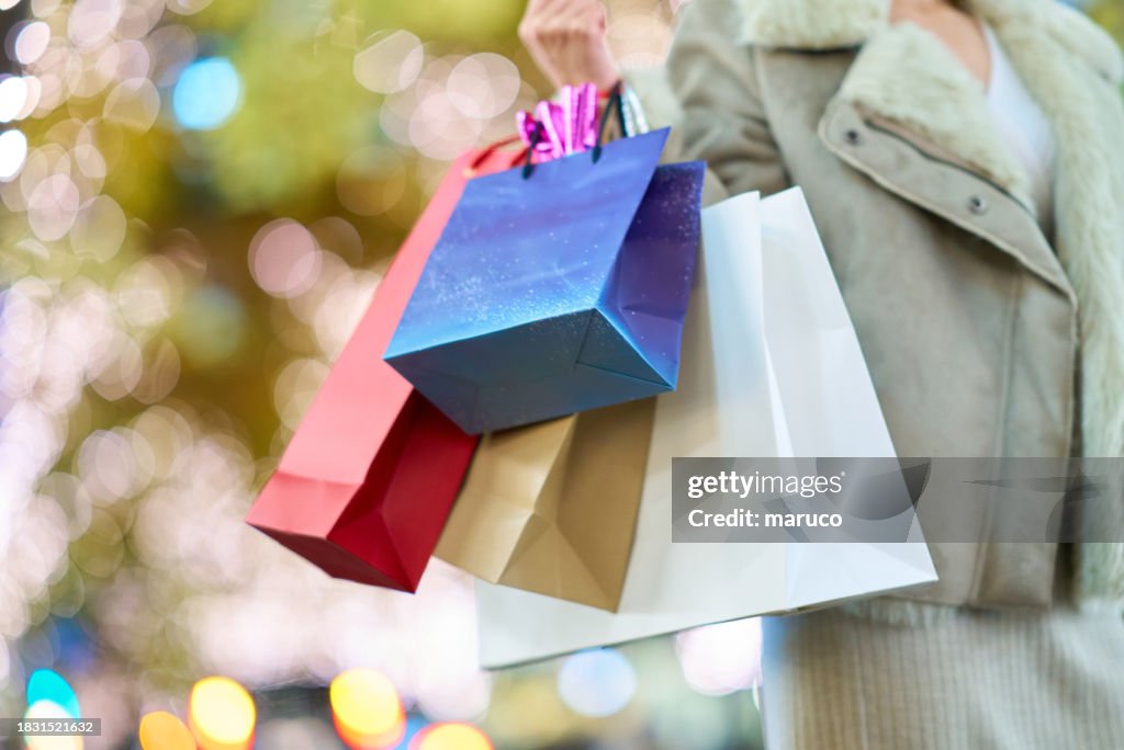 Many shopping bags held by a woman