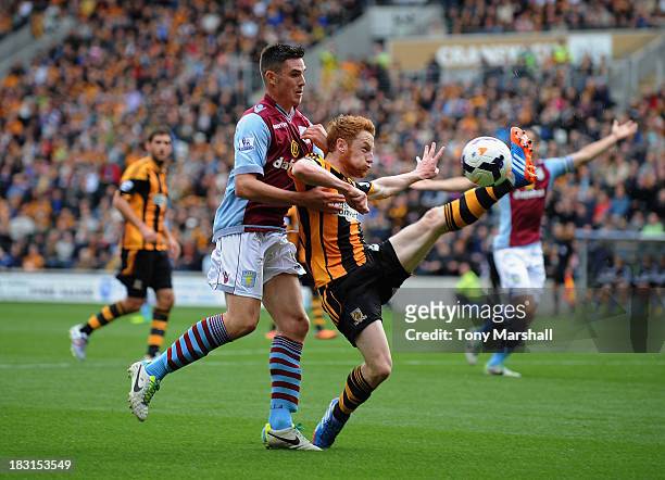 Stephen Quinn of Hull City competes for the ball with Ciaran Clark of Aston Villa during the Barclays Premier League match between Hull City and...